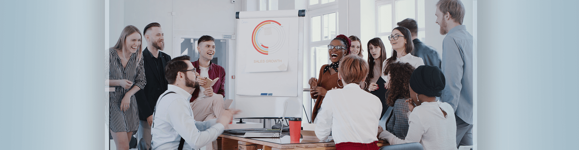 Group of workers laughing in office meeting room