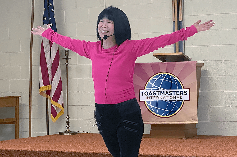 Woman in pink shirt with arms spread out