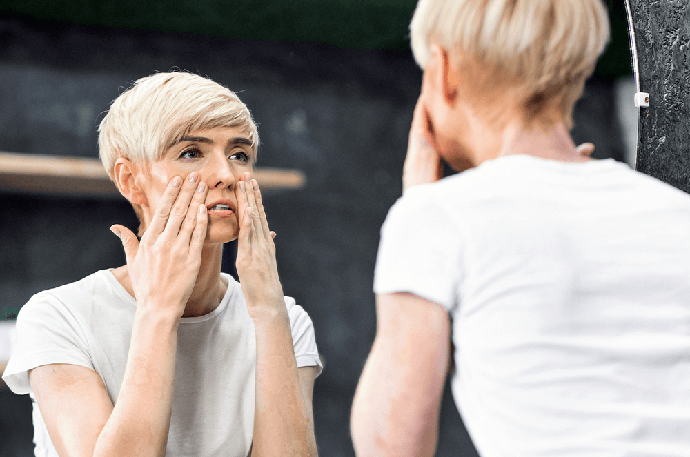 Woman looking at herself in a mirror