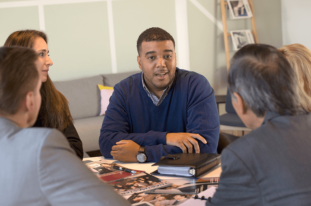 Four people having discussion around table