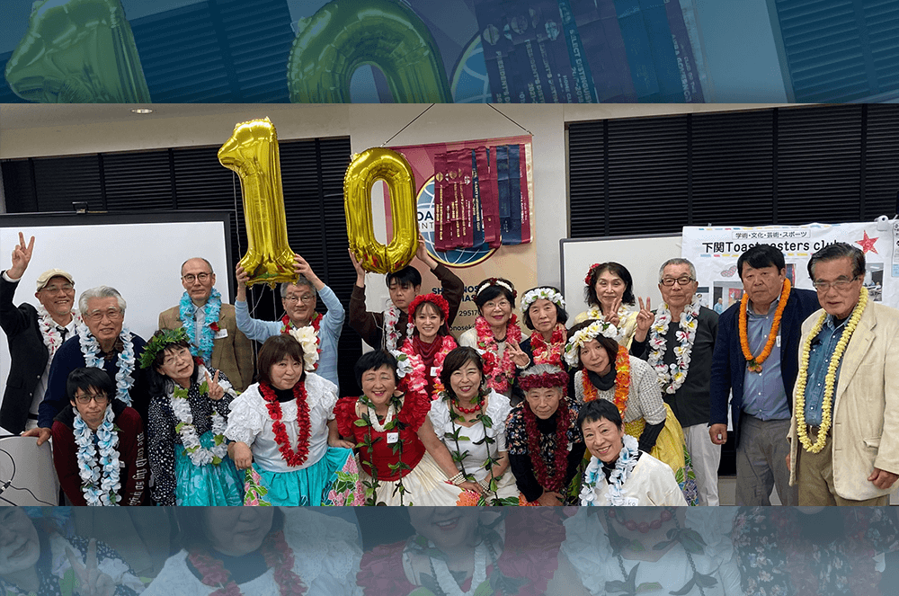 Group of people wearing leis and holding up gold ballons with the number ten