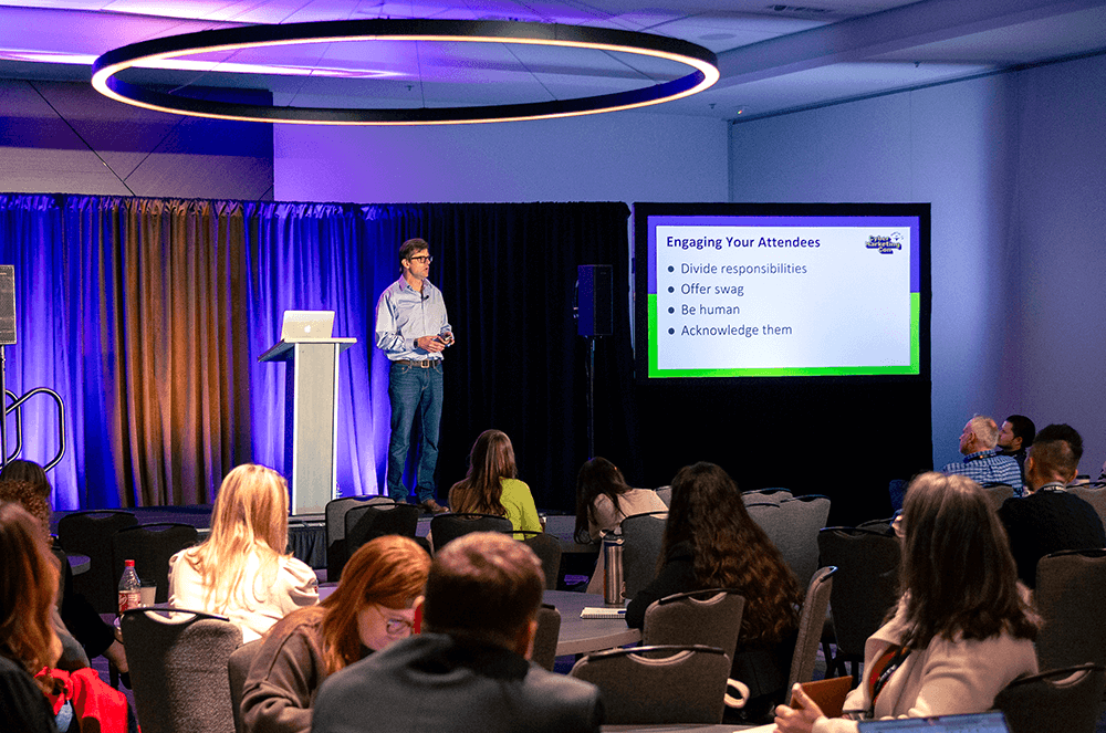 Man presenting on stage with slides