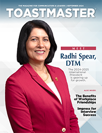 Toastmasters International President Radhi Spear in red jacket smiling on magazine cover