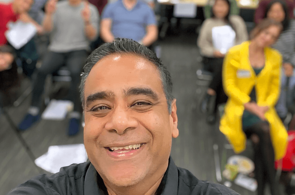 Man smiling in front of a group of people sitting down