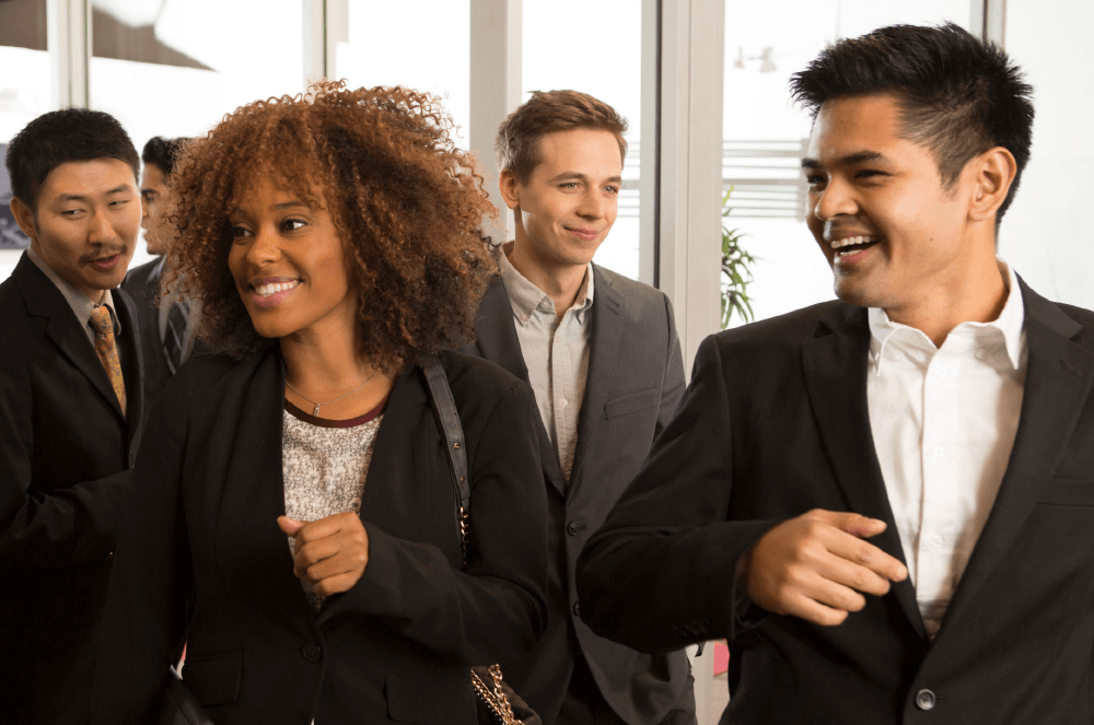 Group of people in suits walking by windows