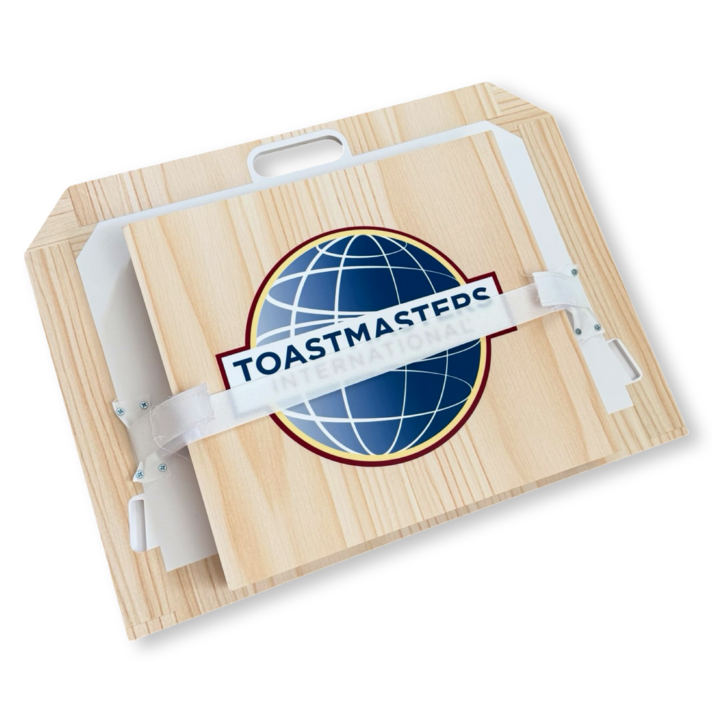 Portable Toastmasters lectern with light woodgrain looking finish and front-facing full-color Toastmasters International logo - shown with velcro strap to keep it secure when not in use. 