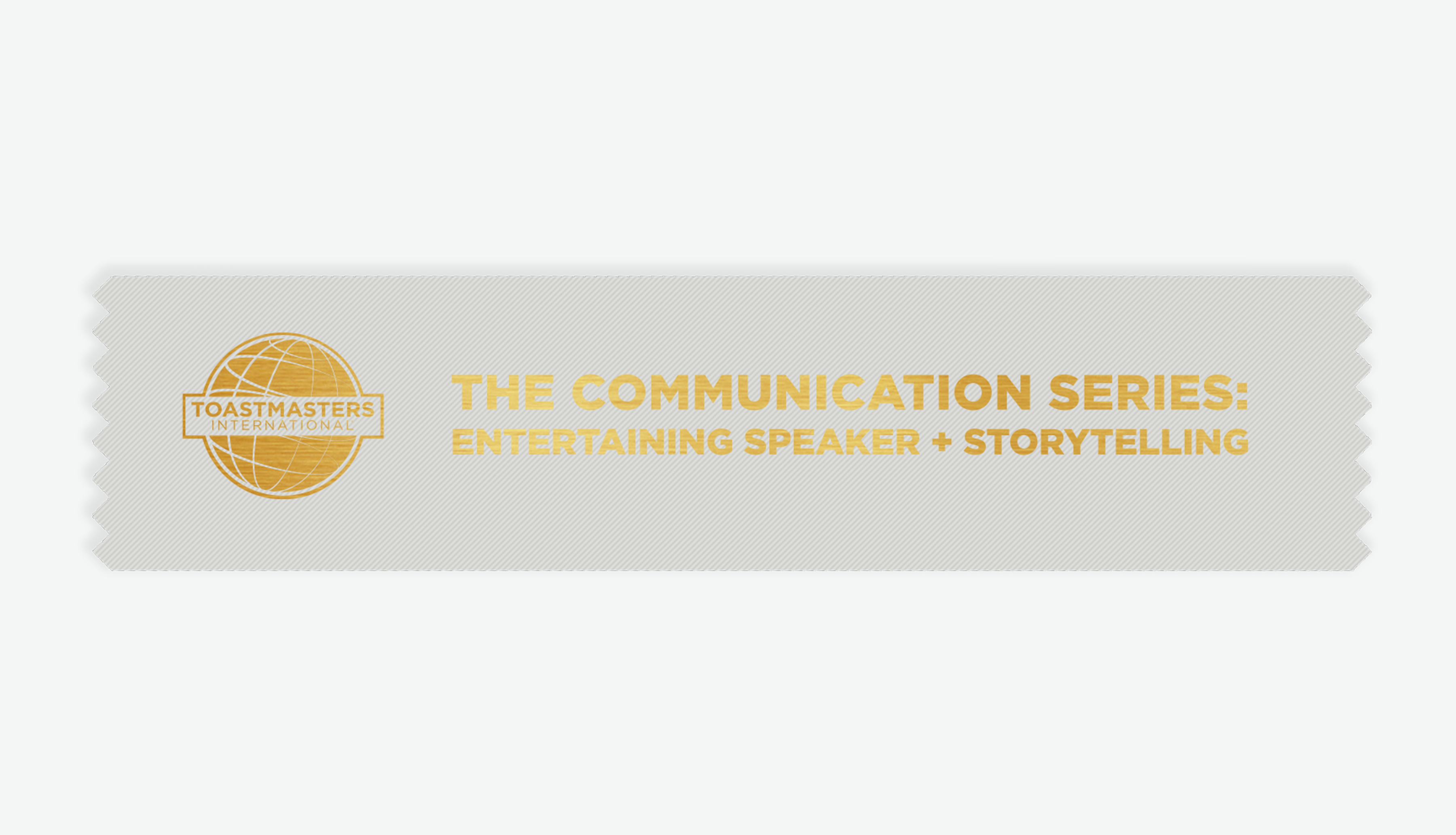 A silver colored ribbon with a gold foil Toastmasters globe logo and the text 