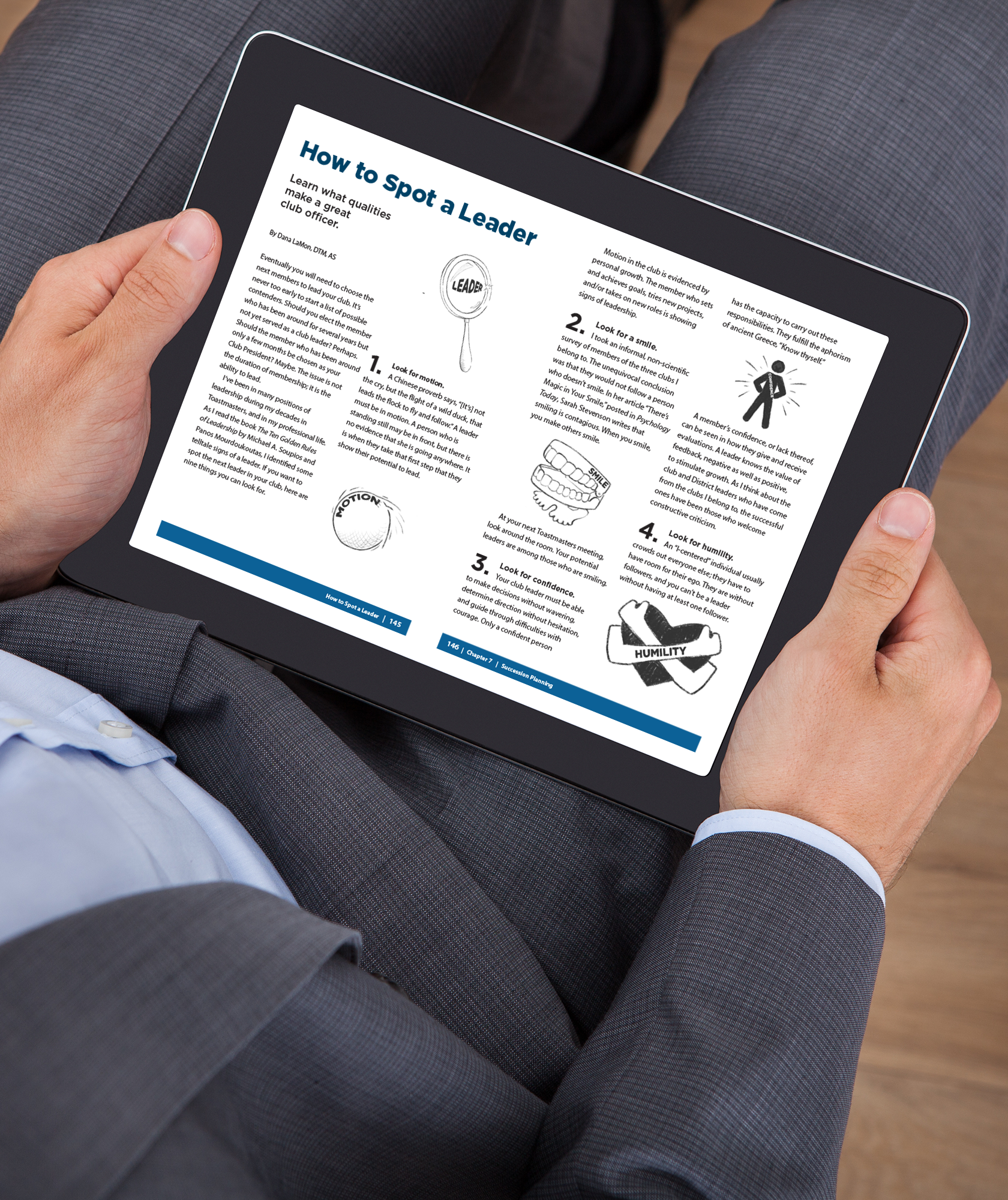 A hand holds a tablet displaying a page from Toastmasters Best of: Club Officer Essentials eBook 
