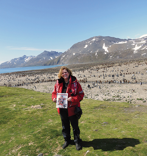 France Castonguay, from Montreal,  Canada, poses with penguins in South Georgia  Island, UK, near the Antarctic Peninsula.