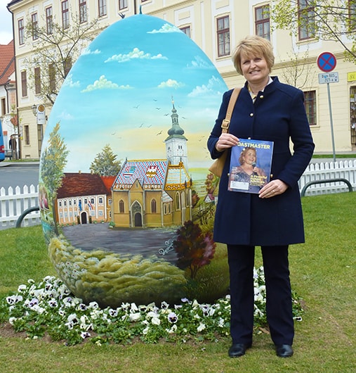 Vesna Kavaz, from Athabasca, Alberta, Canada, stands in front of a hand-painted Easter egg on display in Zagreb, Croatia.