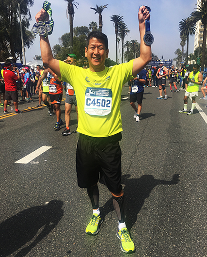 Yu celebrates finishing the LA Marathon in Los Angeles, California in March 2017.