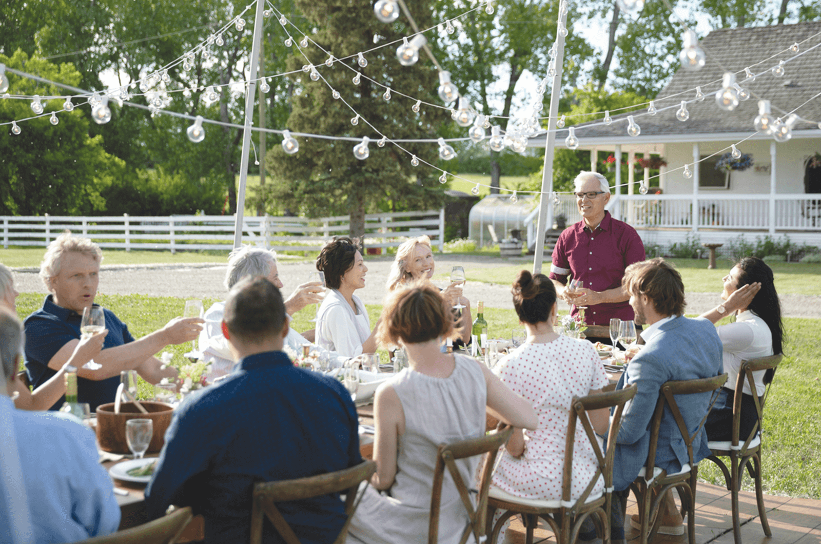 Man standing and giving a toast outside