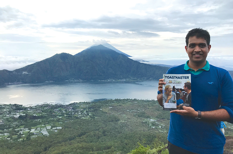 Siddharth Vedulla, CL, from Hyderabad, India, poses after trekking Mount Batur in Bali, Indonesia, with Mount Agung in the background.