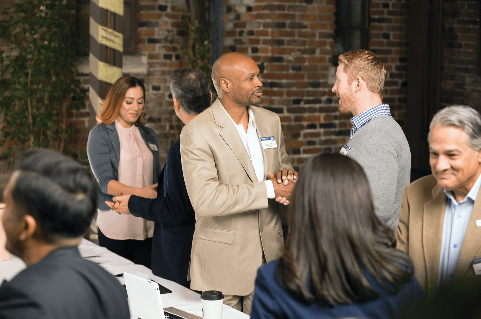 Two men shaking hands at a Toastmasters Open House