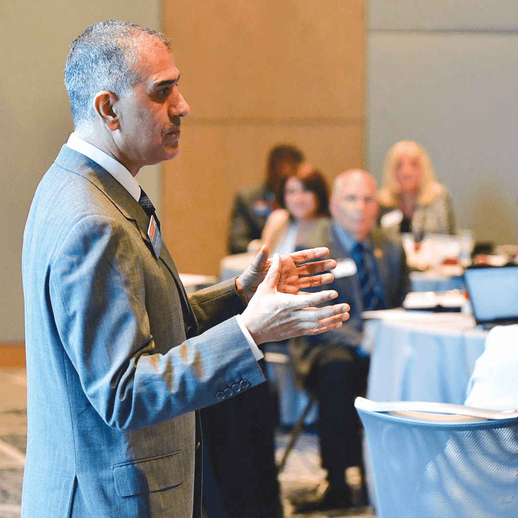 Past International President Mohammed Murad gestures speaking to audience