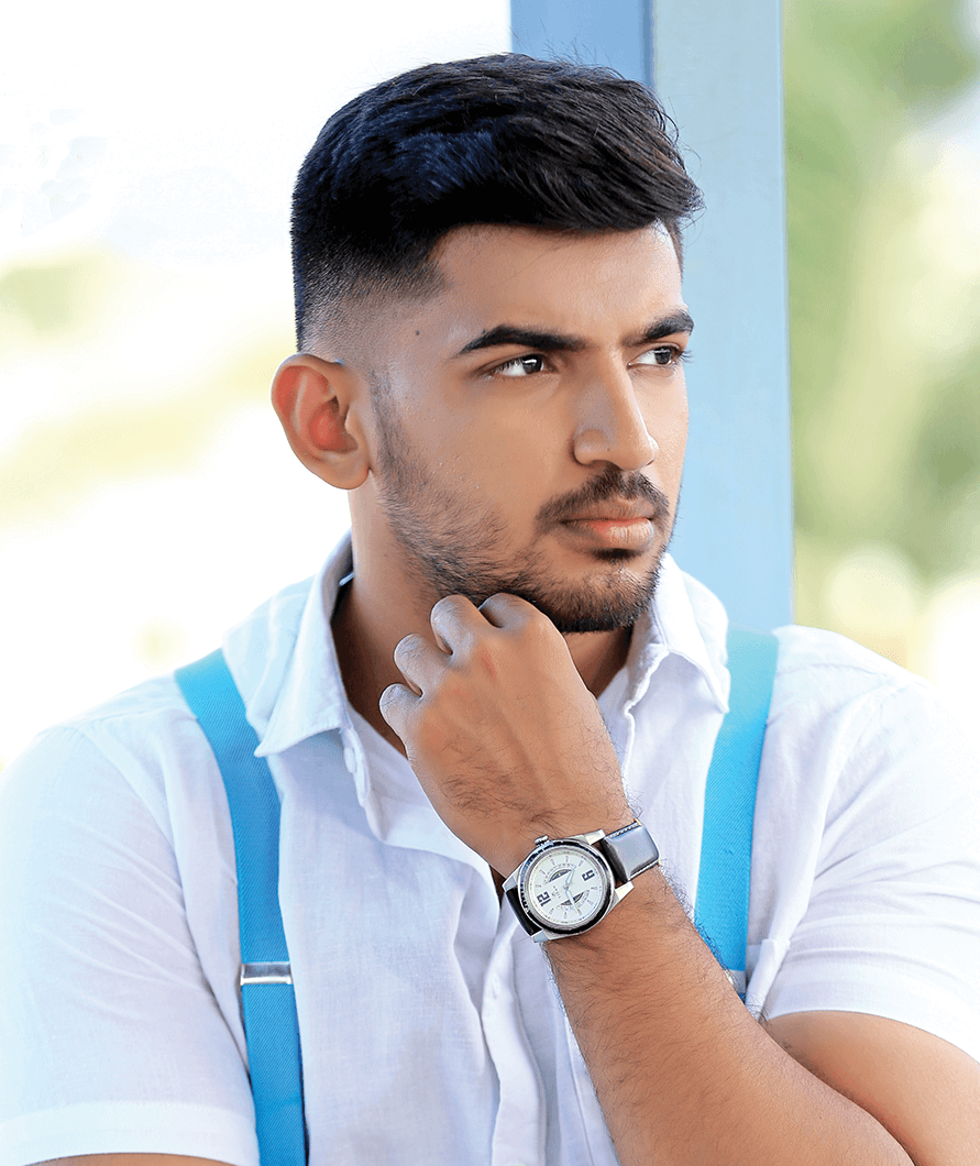 Abishek P in white shirt and blue suspenders poses