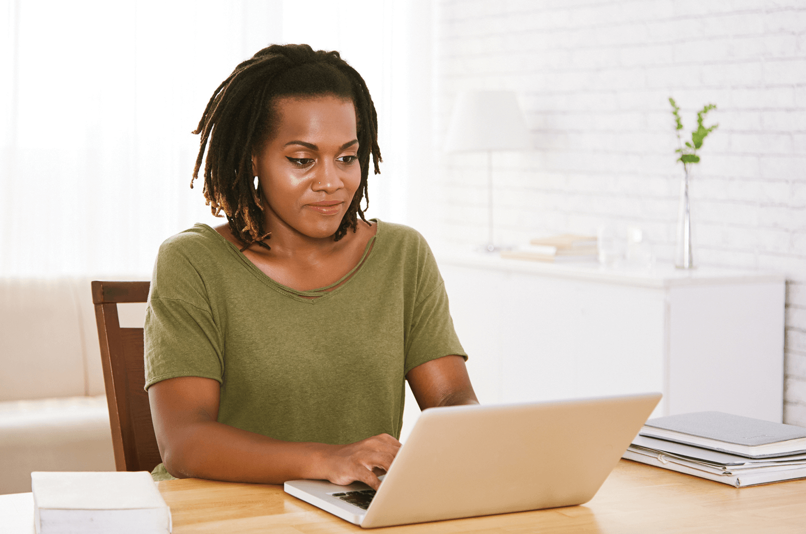 Woman in green shirt on laptop