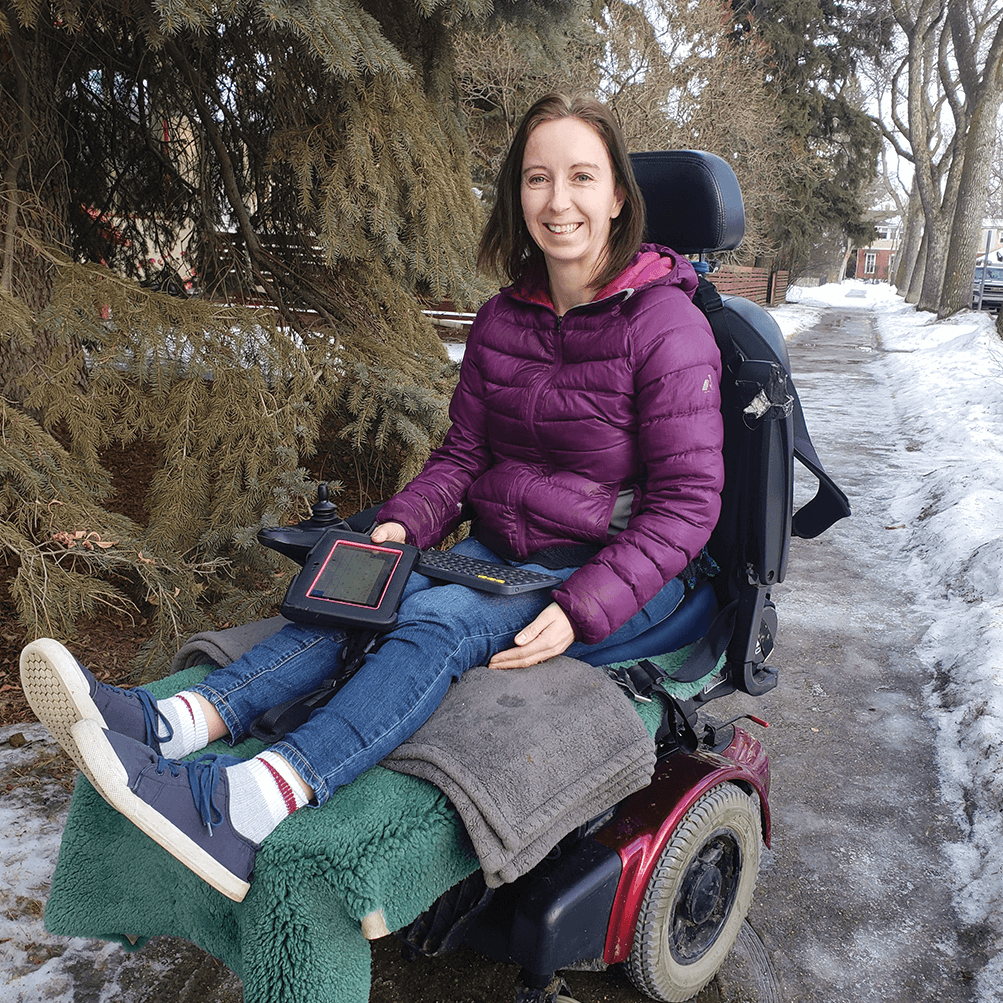 Girl in purple coat poses in wheelchair