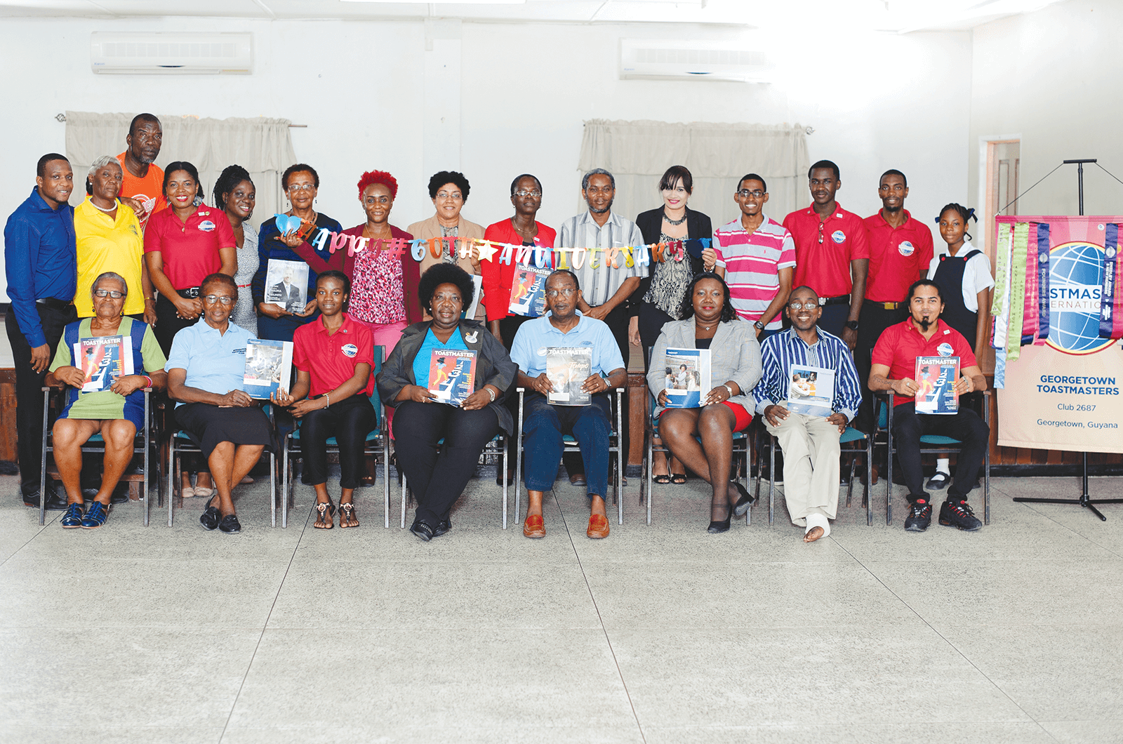 Group of Toastmasters members posing holding magazines