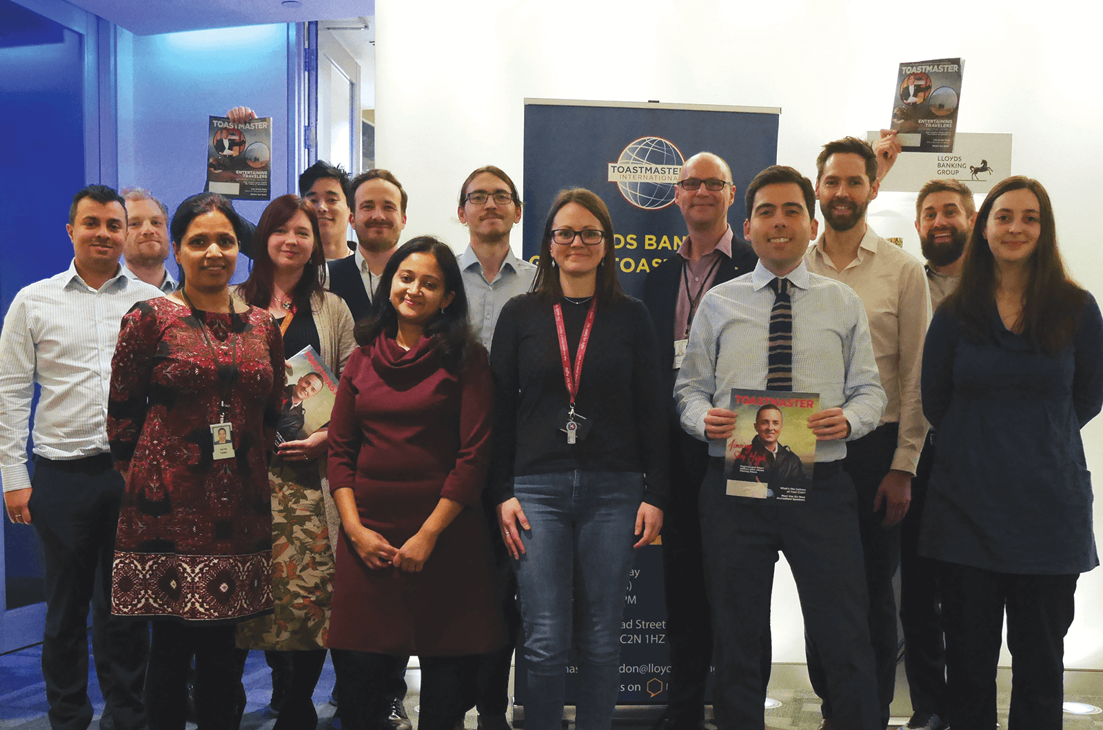 Group of Toastmasters members with hands up celebrating