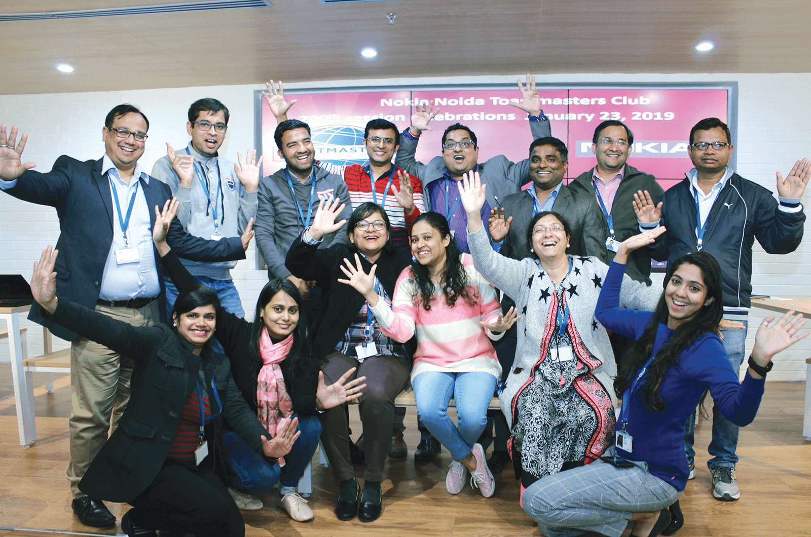 Group of Toastmasters members standing with banner