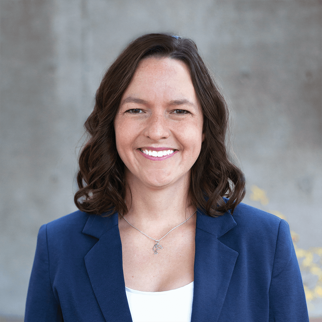 Woman smiling wearing white shirt and blue jacket