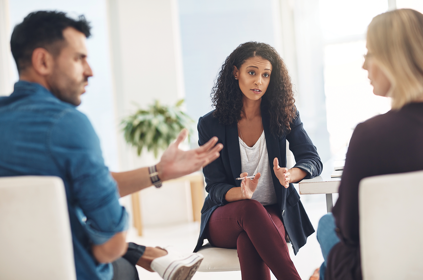 One male and two females sitting and talking