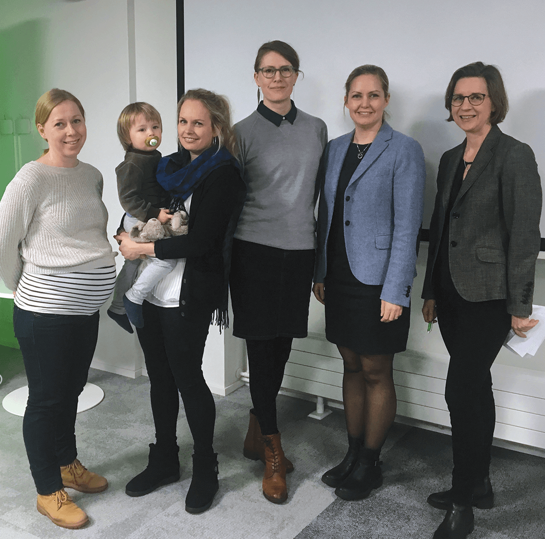 Five female members and a baby pose at a club meeting