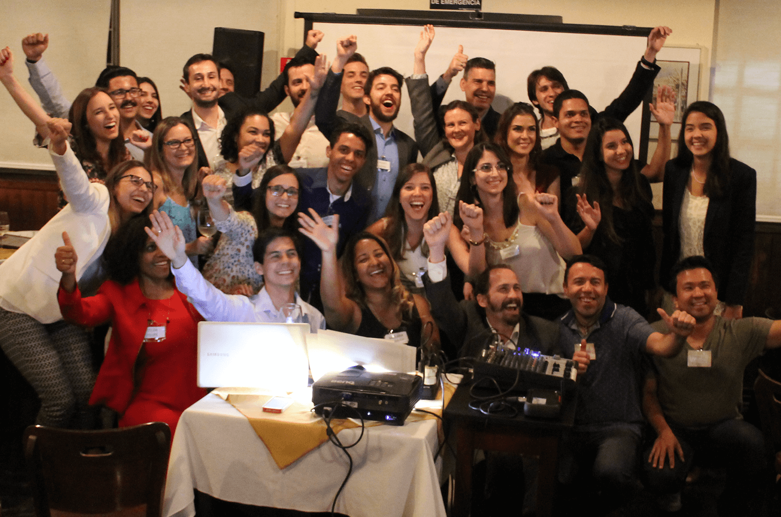 Group of Toastmasters posing with arms in the air