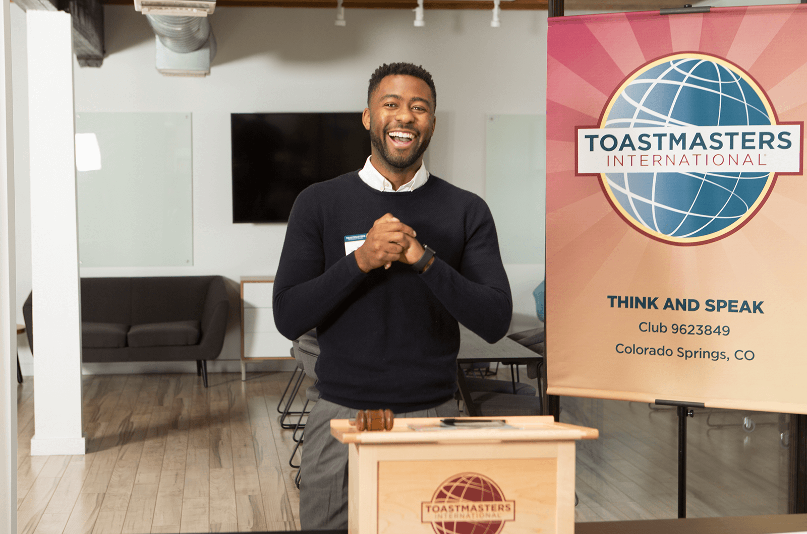 man laughing at podium