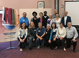 Group of people posing with banner