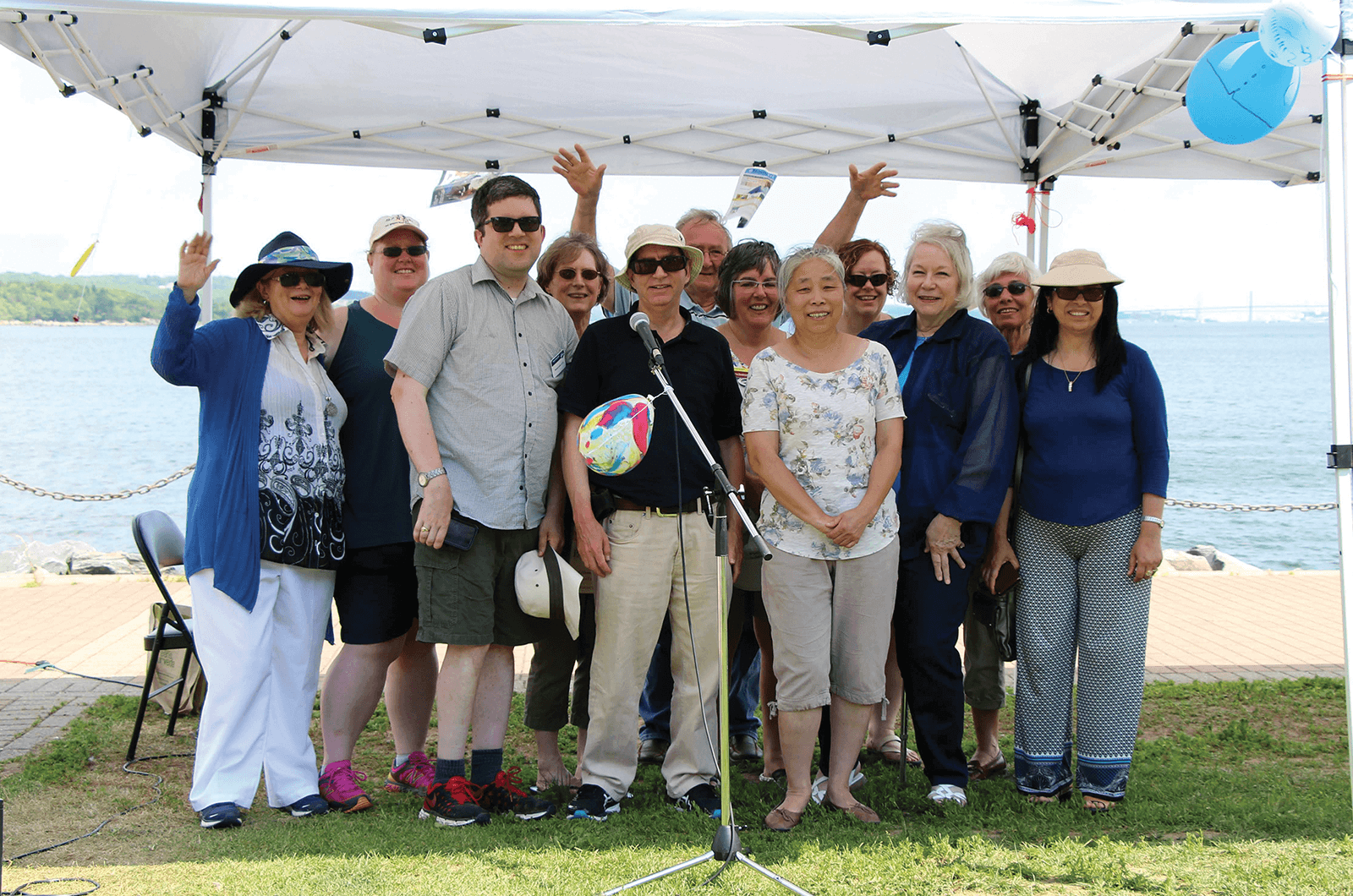 Group of people posing outside under tent