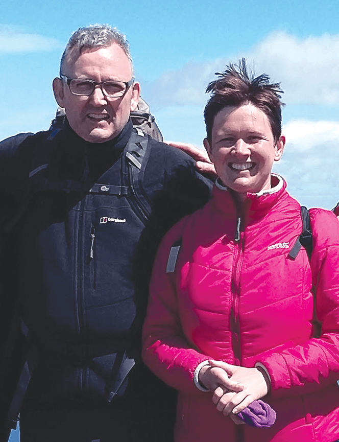 Man and woman wearing coats pose outdoors