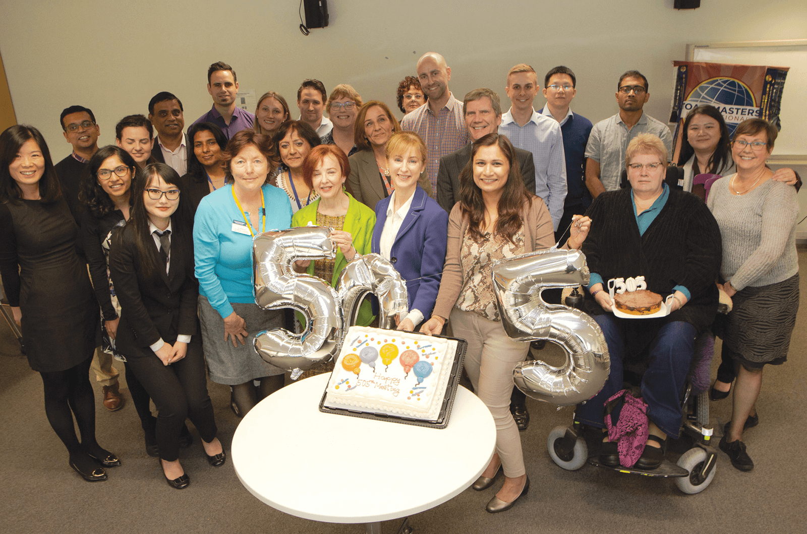 Group of Toastmasters members with silver balloons spelling out 505