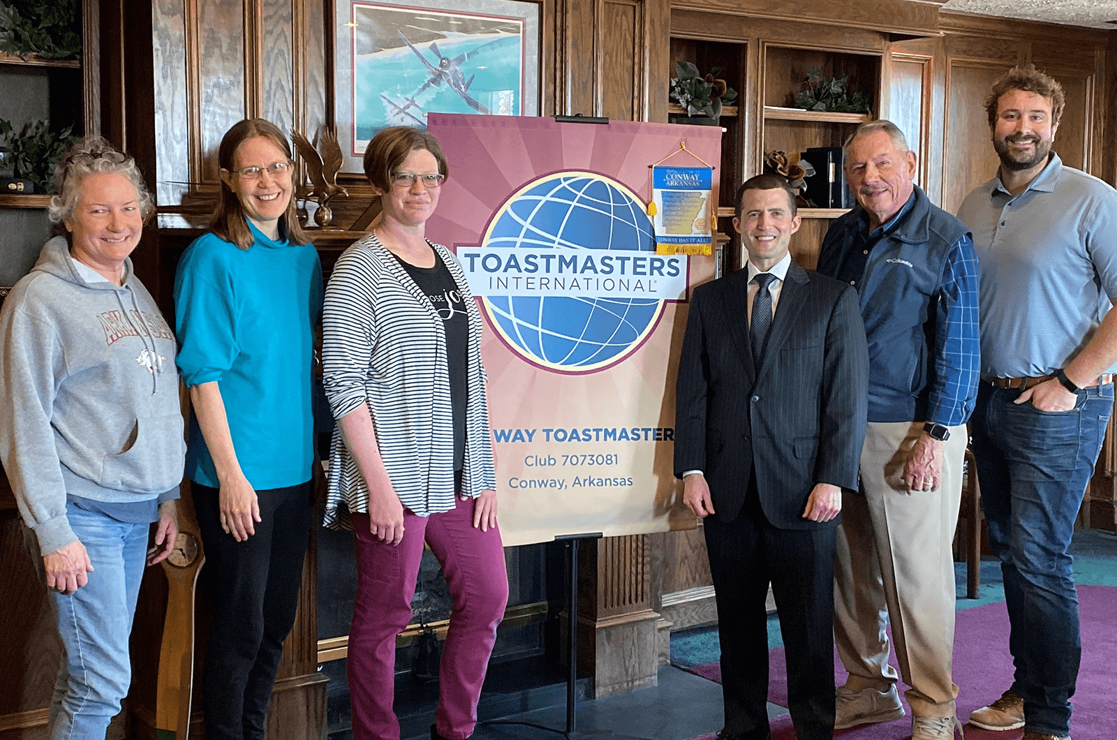 Toastmasters members pose with club banner