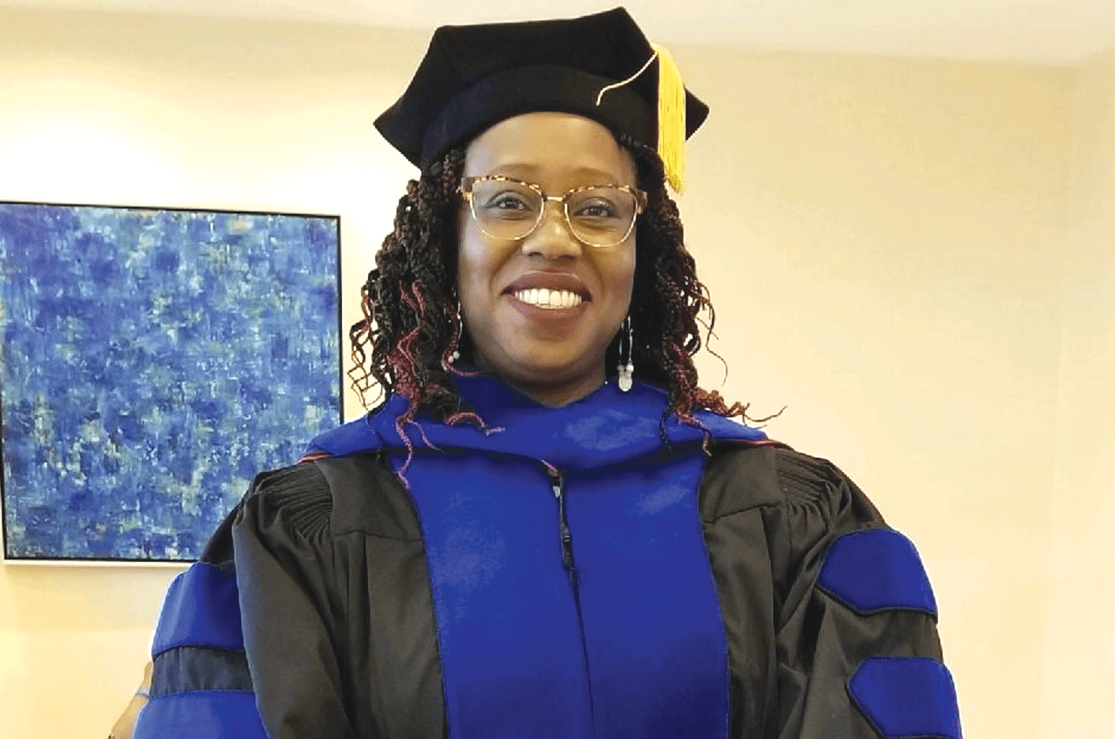 Woman in blue graduation cap and gown