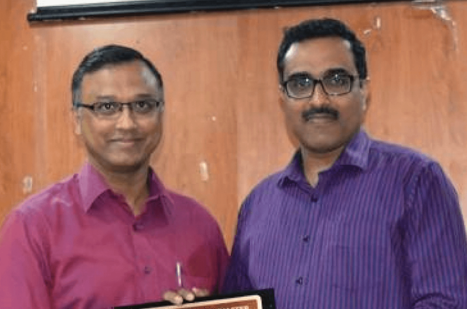 Two members holding plaque