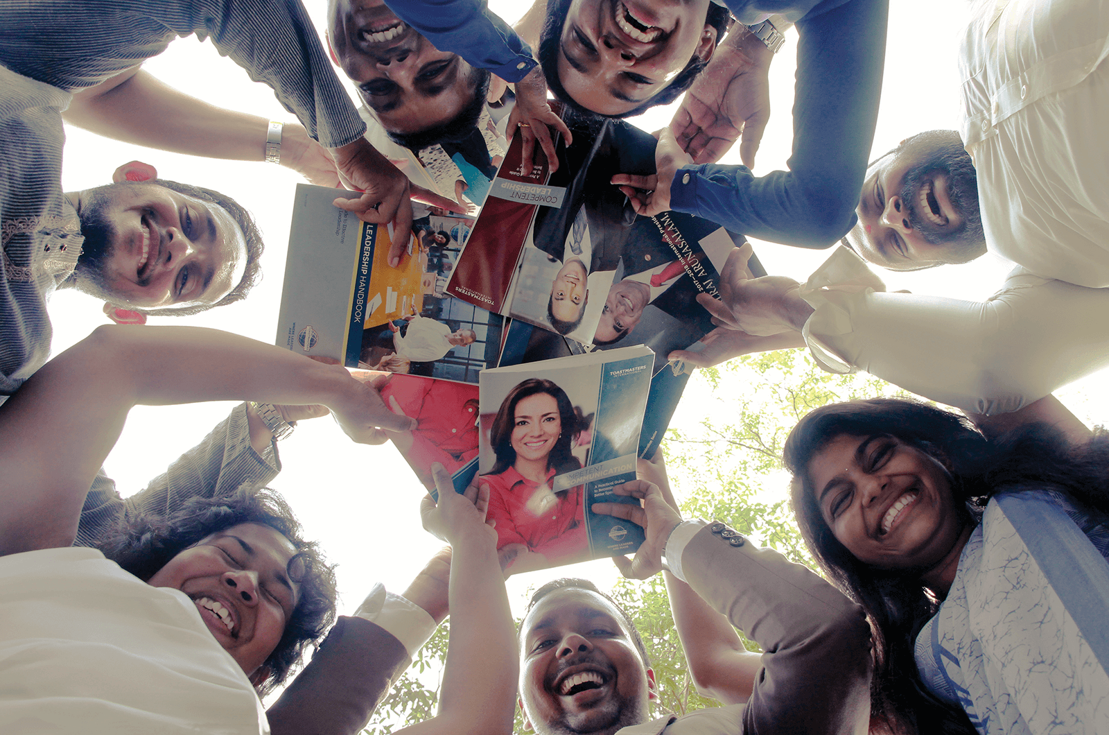 Toastmasters members looking down at camera holding manuals