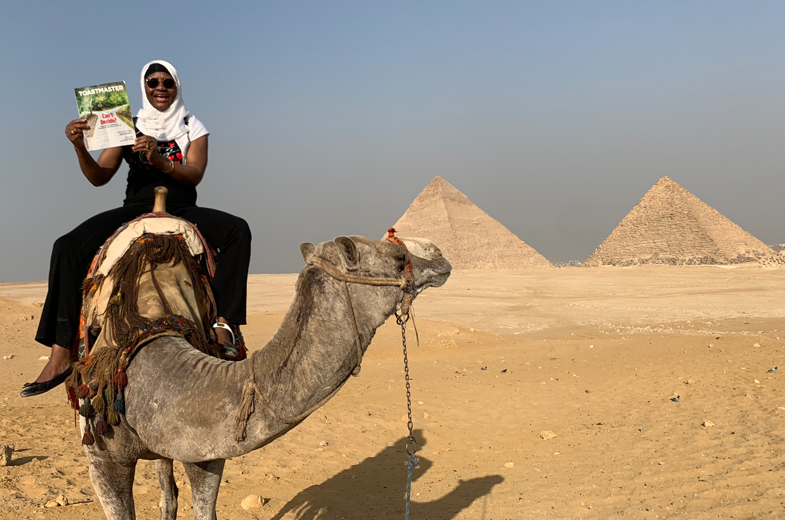 Islamia Adjibi of Bronx, New York, rides a camel near the Pyramids of Giza complex in Cairo, Egypt. The Great Pyramid of Giza, the largest of three structures, is considered one of the Seven Wonders of the Ancient World.  