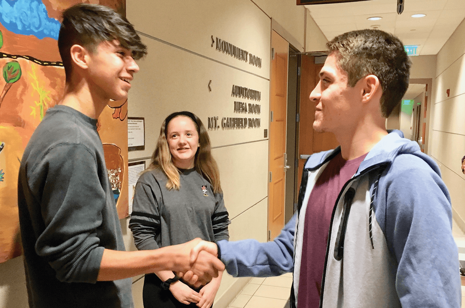 Young man shaking hands with another young man