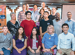 Members of the Chiang Mai club smiling and posing with banner