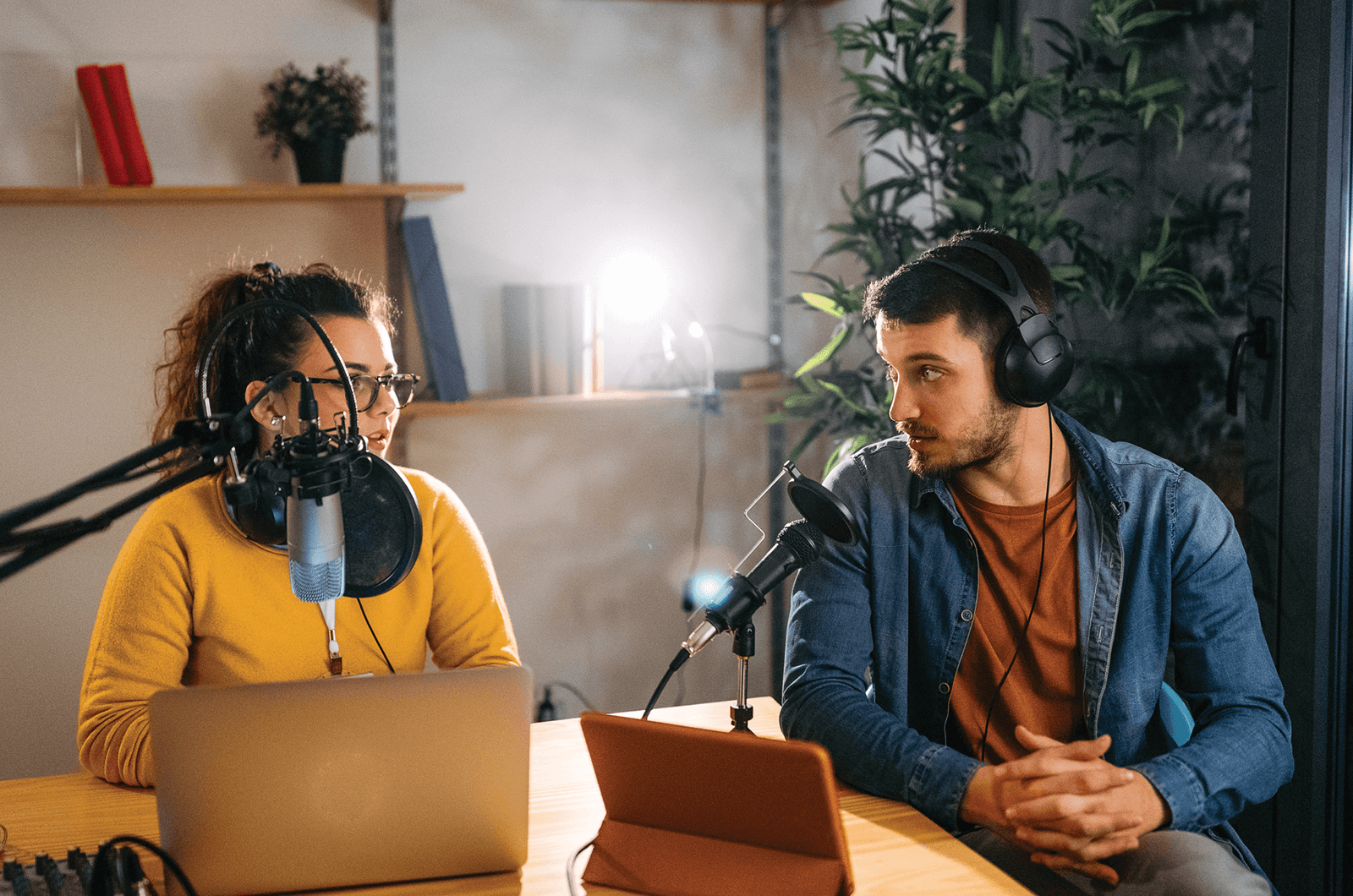 Man and Woman with headphone and microphones podcasting