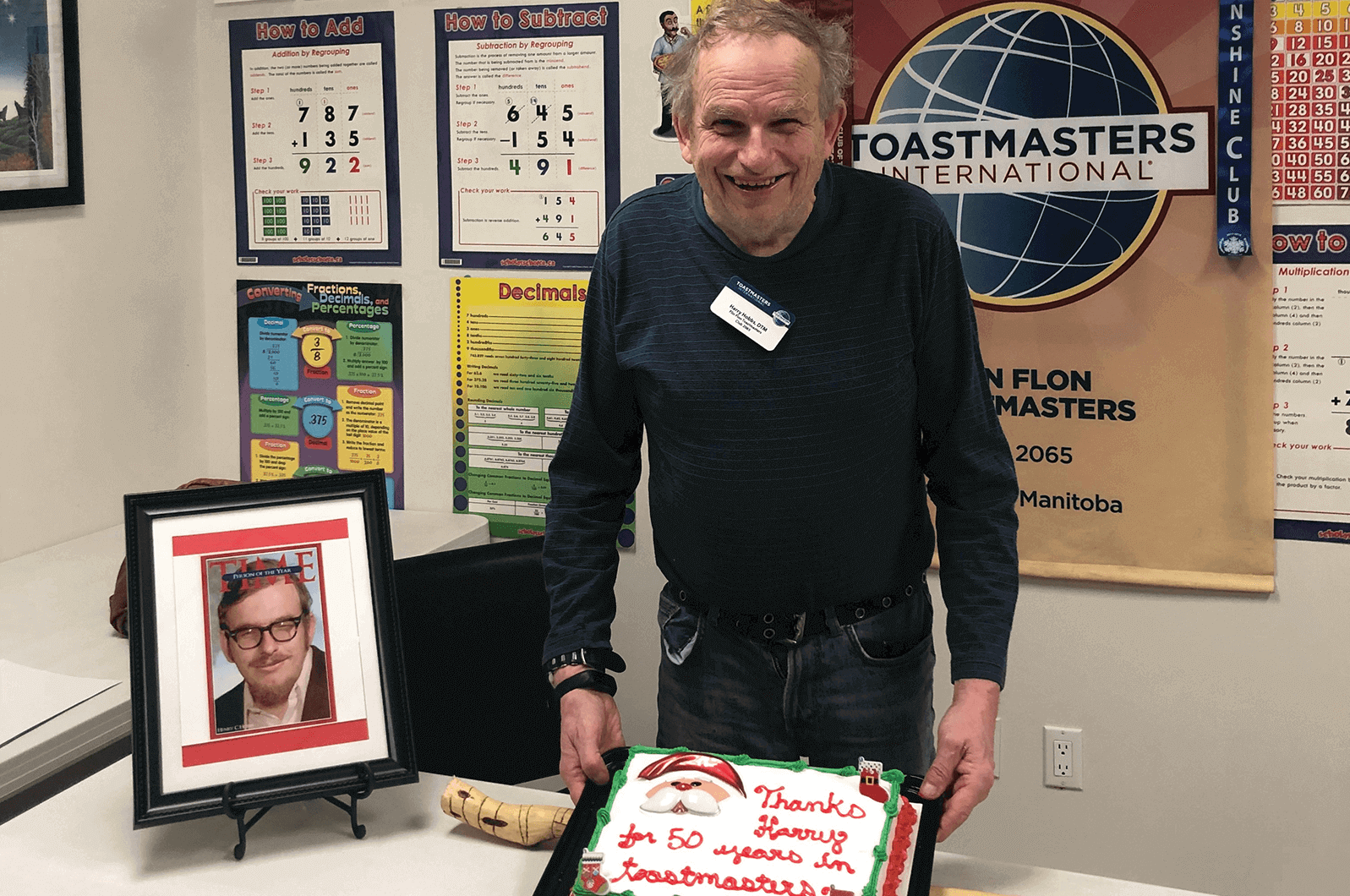 Man posing with banner and cake