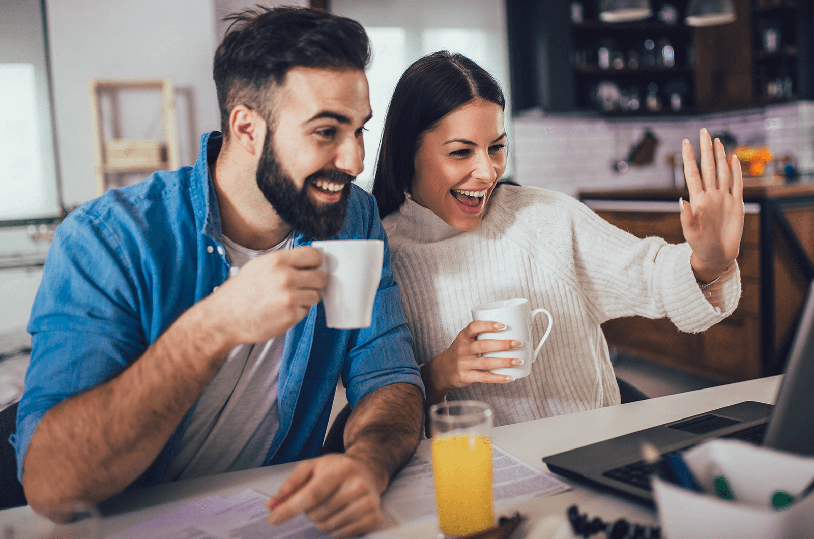 Man in blue shirt and woman in white sweater on video call on lapotop