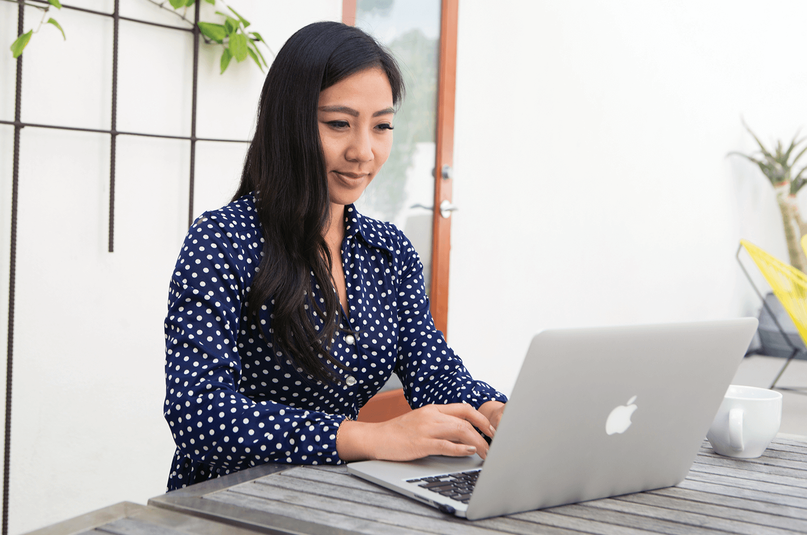 Woman in polka-dot shirt working on computer