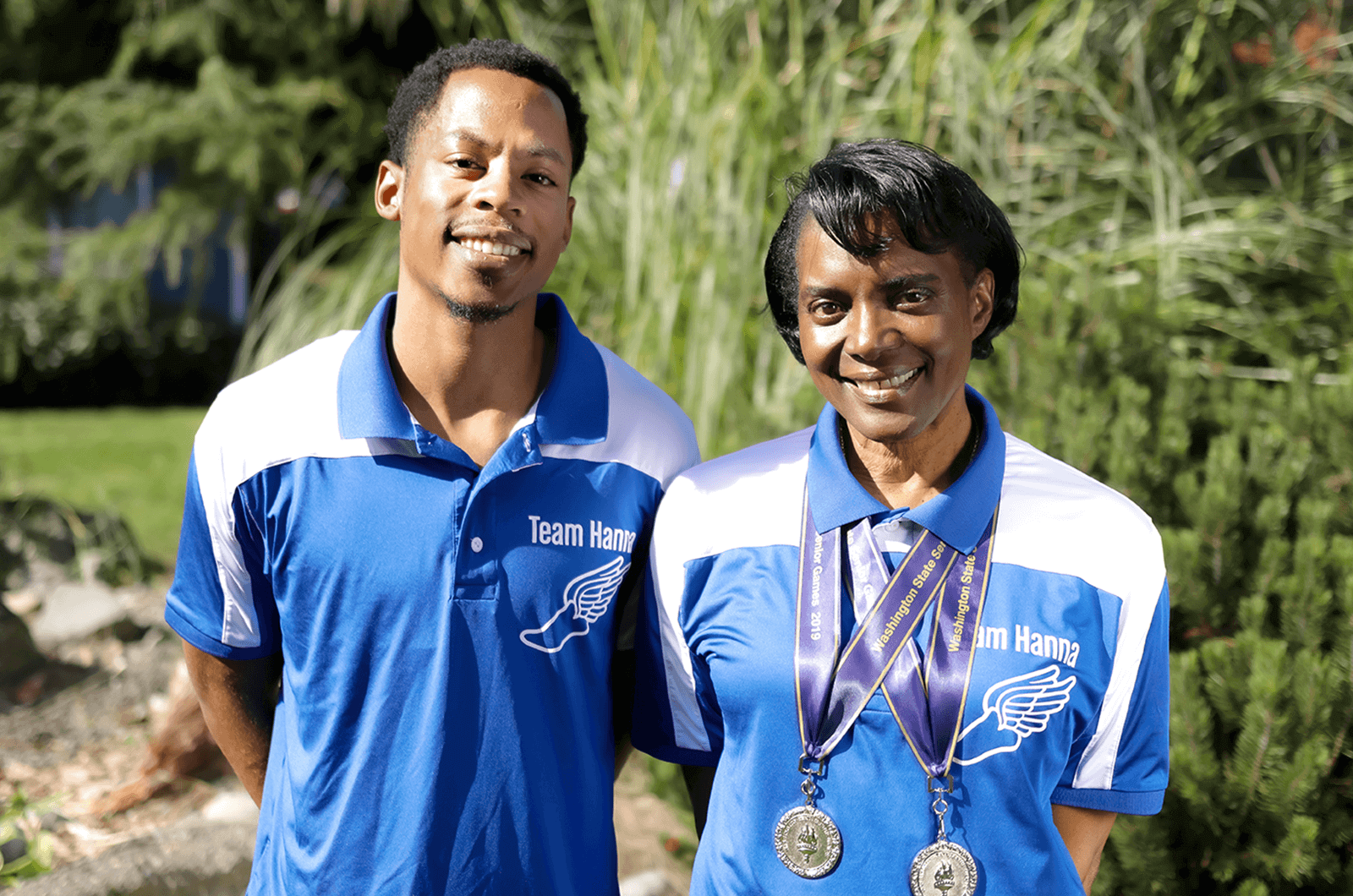 Marcus Chambers and Madonna Hanna pose outdoors in blue and white polo shirts