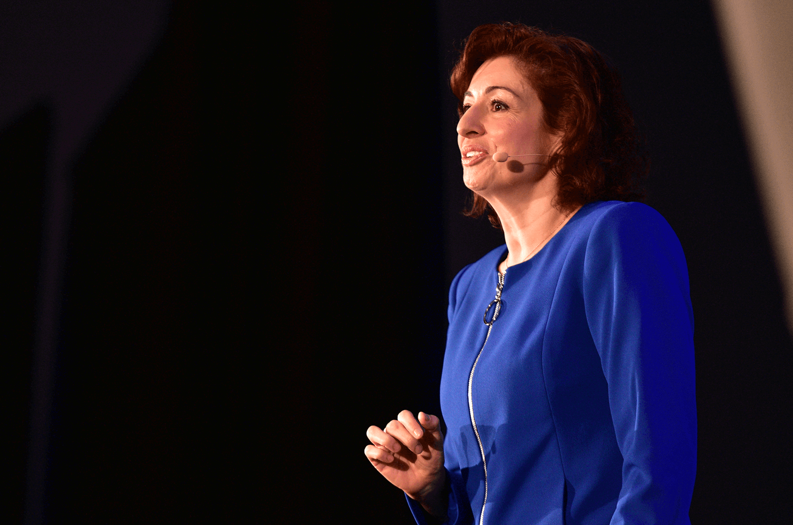 Yelena Balabanova in blue dress speaking to audience