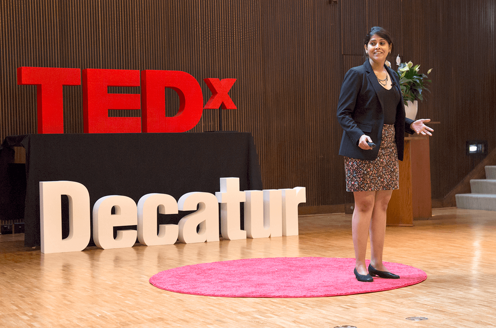 Anwesha Banerjee stands on red dot on TEDx stage