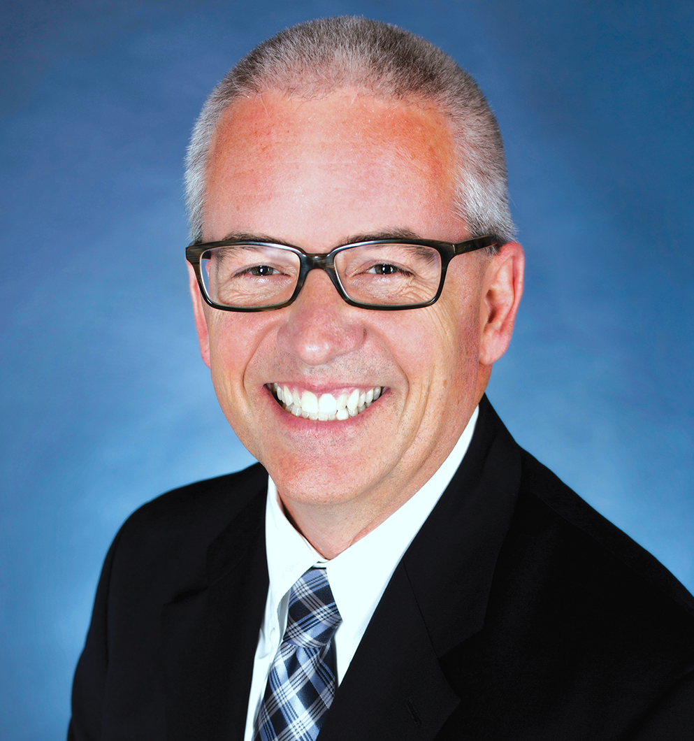 Donald Bittick in suit jacket and tie wearing glasses