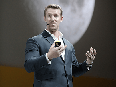 Douglas Kruger speaking onstage using hand gestures